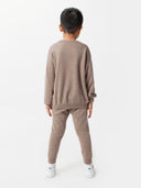 back view of a boy wearing a brown sweater and cashmere pants #color_taupe
