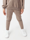 close up bottom side view of a children wearing a brown sweater and cashmere pants #color_taupe