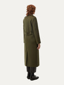 back view of a woman wearing a long green coat on a white background #color_avocado