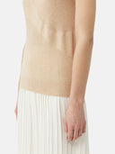 close up of a beige knitted sleeveless top white white skirt #color_beige