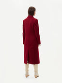 back view of a red cashmere long coat with white boots #color_bordeaux