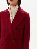 close up of a woman wearing a red double breasted cashmere coat and beige shirt over turtle neck sweater #color_bordeaux