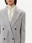 close up of a gray blazer over white shirt and turtleneck sweater #color_vapor-blue