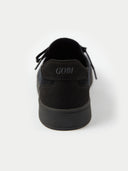 A close-up rear view of a black-colored sneaker, focusing on the suede-like heel counter which features the brand name "GOBI" embossed in the center. The shoe sits on a thick white midsole against a plain white background. #color_black