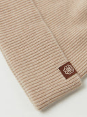 close up of a beige beanie with a small brand logo #color_beige