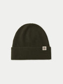 flat lay of a dark green ribbed beanie on a light gray background #color_avocado