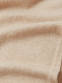 Macro shot of a beige knit fabric with a soft, brushed texture and natural folds. #color_beige