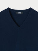 Navy blue sweater with a visible brand label on a light gray background. #color_navy-blue