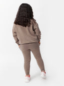 back view of a girl wearing a brown sweater and cashmere pants #color_taupe