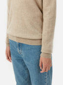 close up bottom side view of a beige sweater and blue jeans #color_warm-grey