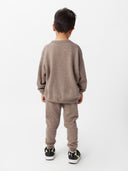 back view of a boy wearing a brown sweater and cashmere pants #color_taupe