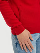 close up of a red cardigan with pocket and jeans #color_racing-red