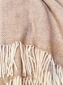 Close-up of a beige scarf with fringes.