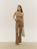 A model wearing brown drawstring ribbed cotton silk cashmere blend flares, standing on a sandy surface.
#color_timber-wolf