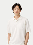 Person wearing a white polo shirt against a plain background #color_whisper-white