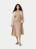 Woman wearing a beige coat and dress set on a white background #color_warm-grey