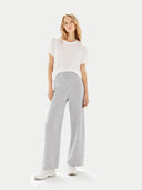 Woman wearing a white t-shirt and gray pants on a white background #color_high-rise