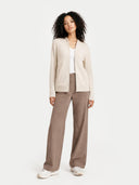 Woman wearing a beige cardigan and brown pants on a white background #color_off-white