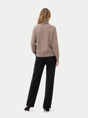 Back view of a woman wearing a beige sweater and black pants on a white background #color_taupe