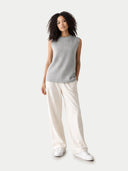 Woman wearing a gray sleeveless sweater and white pants on a white background #color_high-rise