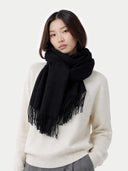 Woman wearing a black scarf and white sweater on a white background #color_black