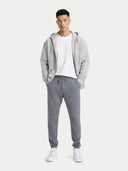 Person wearing a gray hoodie and pants with a white shirt underneath on a white background #color_dim-gray