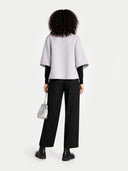 back view of a white top and black pants with a silver handbag on a white background #color_arctic-ice