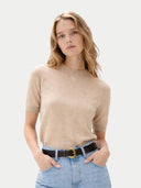 Woman wearing a beige short-sleeve  sweater and blue jeans on a light gray background #color_beige