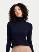 Woman wearing a navy turtleneck sweater against a plain background #color_navy-blazer