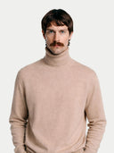 Man wearing a beige turtleneck sweater against a white background #color_beige