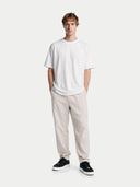 Man wearing a white t-shirt and beige pants on a white background #color_black