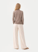 back view of a woman wearing a brown sweater and beige pants on a white background  #color_taupe