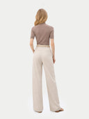 back view of a woman wearing a brown top and beige pants on a white background #color_timber-wolf