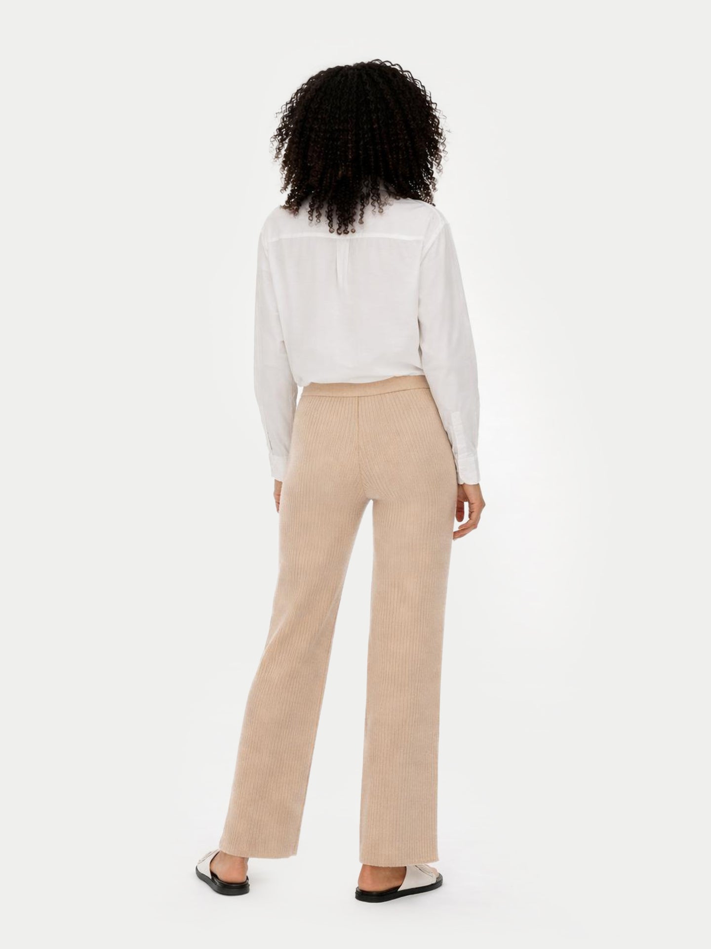Person wearing a white blouse and beige pants on a white background #color_beige