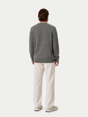 back view of a man wearing a gray square patterned sweater and beige pants on a white background #color_dim-gray
