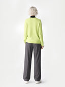 Person wearing a light green sweater and gray pants on a white background #color_sunny-lime