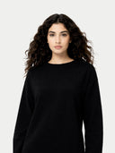 close up of a woman wearing a black crew neck dress against a white background #color_black