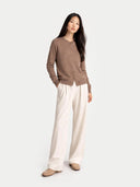 front view of a woman wearing a brown crew neck cardigan and white pants #color_taupe