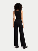 back view of Person wearing a black sleeveless top and wide-leg pants on a white background #color_black