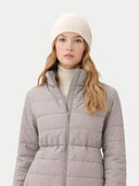Woman wearing a gray puffer jacket and white beanie on a light gray background #color_cement