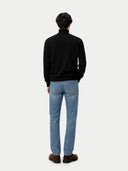 back view of a person wearing a black sweater and light blue jeans on a white background #color_black