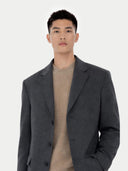 close up of a Man wearing a gray coat over a beige sweater on a white background #color_charcoal