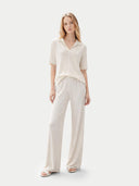 Woman wearing a white outfit on a light gray background #color_whisper-white