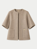 A beige short-sleeve wool jacket with a round neckline, front button closure, and two front patch pockets, shown on a light gray background.