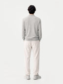 back view of Person wearing a gray sweater and white pants standing against a white background #color_vapor-blue
