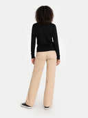 back view of a Person wearing a black long-sleeve sweater and beige pants on a white background #color_black