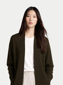 close up of a woman wearing a dark brown cardigan over a white shirt on a light gray background #color_avocado