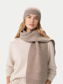 Woman wearing a beige knit hat and scarf on a light gray background #color_taupe