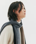 Person wearing a gray scarf with a plain background