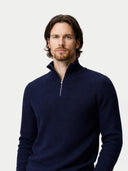 Man wearing a navy blue quarter-zip sweater on a light gray background #color_navy-blazer